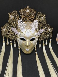 Venetian Mask for decoration - Traditional and original papier-mache Venetian mask, handmade and decorated with metal insert, gold-leaf and glitters, enriched with Swarovski crystals. Dimension::Hight 35cm,width 28cm Decoration only,not wereable All our masks are handmade paper-machè masks made in Venice. Our decorators use techniques typical of the Venetian tradition such as stucco, acrylics, gold and silver-leaf, macramè, passementerie, glitters and crequelè to offer you a wide range of origin Elegant Gold Masquerade Mask As Gift, Gold Eye Mask For Costume Party, Gold Carnival Eye Mask, Gold Mask For Masquerade, Gold Eye Mask For Mardi Gras, Gold Fantasy Style Masquerade Mask, Gold Eye Mask For Carnival, Gold Fantasy Masquerade Mask For Party, Gold Masquerade Mask For Carnival