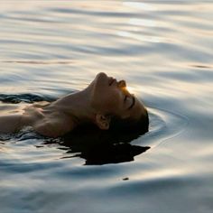 a person floating in the water with their head above the water's surface and his eyes closed