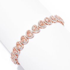 Fall in love with your accessories! This adorable bracelet showcases a line of morganite gems in the shape of a heart surrounded by a halo of gorgeous white zircon gemstones. This heart bracelet is crafted in 18K rose gold vermeil over sterling silver. Coming in your choice of size, it's sure to be the perfect fit for your wrist and your collection. It would look lovely on its own, or pair it with the matching earrings, pendant and ring for a complete look! Luxury Heart-shaped Diamond Bracelet For Valentine's Day, Heart Cut Diamond Bracelet For Valentine's Day, Valentine's Day Rose Gold Diamond Bracelet, Luxury Cubic Zirconia Diamond Bracelet For Valentine's Day, Luxury Cubic Zirconia Bracelet For Valentine's Day, Rose Gold Diamond Heart Bracelet Fine Jewelry, Luxury Diamond Bracelet With Accents For Valentine's Day, Rose Gold Diamond Heart Bracelet In Fine Jewelry Style, Luxury Diamond Bracelets For Valentine's Day