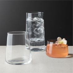 three different types of glasses sitting on a table next to each other and one is filled with ice