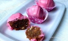 three pink cupcakes are on a white plate