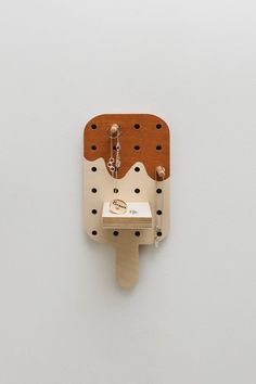 a white wall with a wooden object on it's side and holes in the middle