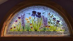 an arched window with flowers painted on it