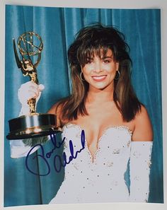 an autographed photo of a woman in white dress holding her award for outstanding actress