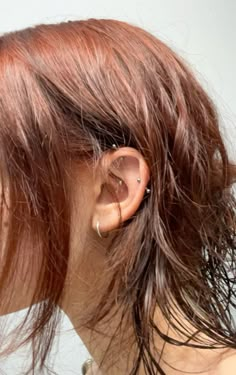 the back of a woman's head with ear piercings