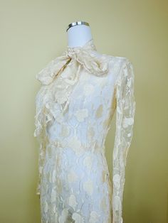 The magic of this dress cannot be overstated. Beautiful cream lace with intricate leaf / floral embroidery design. Fitted int he bodice with gently flared skirt. Pointed princess cuffs. Side snap closures. Comes with a matching tie that can be worn a variety of ways. Does have some stretch but due to age I suggest not stretching too much! Condition: Great! There are a couple of rust colored dots literally not visible when worn and looks practically unworn. Delicate and stunning.  Measurements: Pit to pit 36-38" Waist: 28-30" Hips: 46" Length: 57" ---------- I do not accept returns currently. Please read the description in detail and ask any and all questions before you purchase. However, if you have a problem DO message me, as I am flexible on a case by case basis! ALL ITEMS ARE SHIPPED FR Fitted Cream Gown With Floral Embroidery, Elegant Fitted Lace With Floral Embroidery, Elegant Lace Vintage Dress For Formal Occasions, Elegant Lace Vintage Dress For Formal Events, Elegant Vintage Dress With Lace Collar For Vintage Events, Vintage Dresses With Fitted Bodice For Ceremony, Vintage Ceremony Dresses With Fitted Bodice, Cream Fitted Lace Dress For Ceremony, Fitted Cream Lace Dress For Ceremony