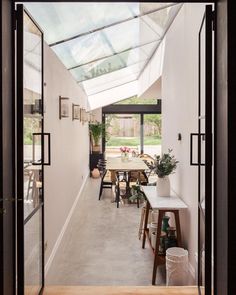 an open door leading to a dining room with glass roof and skylights on the ceiling