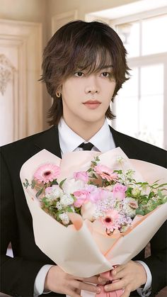 a man in a suit holding a bouquet of flowers and looking at the camera with an intense look on his face