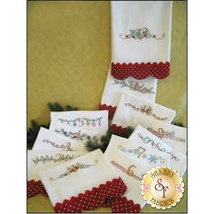 six embroidered christmas napkins with red trim