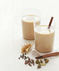 two glasses filled with milk and cinnamon on top of a table