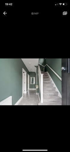 an empty hallway with stairs and green walls