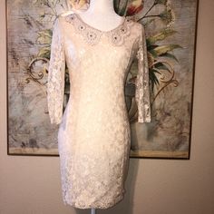 Nwt Never Worn, Size Small, 92% Nylon 8% Spandex Stretch Ivory Lace Dress, Fully Lined With An Ivory Stretch Jersey Like Fabric, Trendy Statement Doily Lace Collar With Pearls, And Rhinestones. Open Oval Back Wtih 2 Pearls And Loops Closure At The Top. Back Zipper Easy To Put On. Dress Hits Above The Knee. Retail: $80 Armpit To Armpit: 17” Sleeve Length From Top Shoulder: 18.5” Length From Back Shoulder: 30.5” Waist Laying Flat: 15” **New To Poshmark Use My Referral Code Michelemc_2021 On Your F Spring Wedding Stretch Bodycon Dress, Cream Bodycon Mini Dress For Party, Elegant White Stretch Dress, Cream Stretch Mini Dress, Cream Fitted Bodycon Party Dress, Cream Fitted Bodycon Dress For Party, Chic Cream Stretch Dress, Elegant White Stretch Lace Dress, Beige Stretch Lace Dress