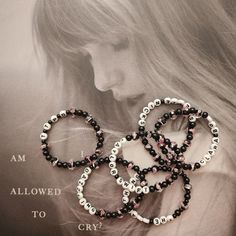 three black and white beaded bracelets on display in front of an advertisement for jewelry