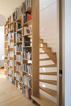 a bookshelf filled with lots of books next to a stair case