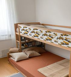 there is a bunk bed with a construction truck print on the mattress and pillow under it