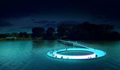 people are standing on an artificial floating platform in the middle of water at night time