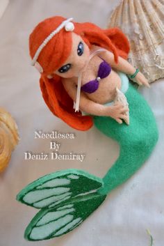 a little mermaid doll sitting on top of a table