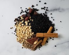 an assortment of spices and nuts on a marble surface