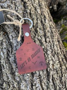 a leather tag hanging from the side of a tree