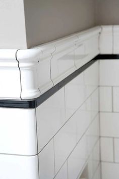 the corner of a white tiled kitchen with black trim