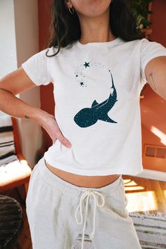 💫 A whale shark leaves behind a trail of stars on this cute baby tee. 🌊 🌞 FEATURES: *  Made with 100%, midweight (5.3 oz/yd² (180 g/m US cotton that feels soft to the touch and a great choice for any season (SOLID COLORS) * The crew neckline along with the tee's classic fit, deliver a timeless style that is perfect for daily use. * All t-shirts come with pearlized, tear-away labels for total comfort and a scratch-free experience. * Made using ethically grown and harvested US cotton. Gildan is Whale Shirt, 90s Era, Cute Shark, Coconut Girl, Marine Biology, Ocean Inspired, Whale Shark, Girl Shirt, Ocean Animals