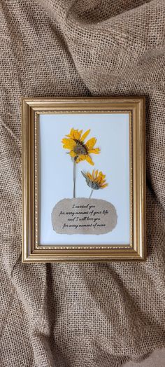 two yellow sunflowers are in a gold frame