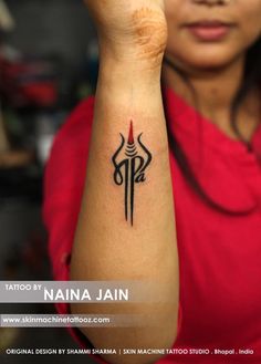 a woman holding up her arm with a tattoo on it's left hand and an arrow in the middle