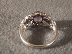 I am offering you this spectacular vintage sterling silver ring. This piece is stunningly beautiful with the following features: * Large oval amethyst dominates this ring * Individually set stone with four prongs and small round diamonds accent the center stone * beautiful cut away wide band and scrolling pattern * ring size 8 This is a classic piece with many fine features. There is tons of sparkle and shine with this piece. Buyer pays all shipping and handling. Victorian Purple Ring With Center Stone, Victorian Style Purple Ring With Center Stone, Vintage Amethyst Ring With Accent Stones For Wedding, Vintage Amethyst Ring With Accent Stones For Anniversary, Victorian Amethyst Ring For Anniversary, Vintage Purple Rings With Accent Stones, Vintage Purple Crystal Round Ring, Vintage Purple Round Crystal Ring, Vintage Purple Promise Ring