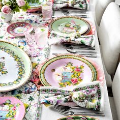 the table is set with many plates and silverware, including one that has flowers on it