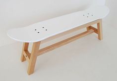 a white skateboard sitting on top of a wooden bench with holes in the bottom