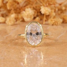 a close up of a ring on a table with flowers in the backgroud