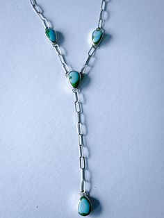 This one-of-a-kind Lariat necklace features a Y-shaped design that consists of four hand-fabricated turquoise pendant pieces. Each stone is Sonoran Mountain Turquoise, which has a beautiful complexion with variations of blues and greens. An elegant paperclip chain links all the pendants together. The piece is finished with a high polish to make it shine! MATERIALS Sonoran Mountain Turquoise Sterling Silver DIMENSIONSNecklace measures 20" with a 3.5" drop. Note: the paperclip chain allows you to wear the necklace at any length 20" or less! Simply clip at any length you'd like! Turquoise Lariat Gemstone Jewelry, Turquoise Lariat Jewelry With Adjustable Chain, Turquoise Lariat Necklace In Sterling Silver, Turquoise Lariat Jewelry With Natural Stones, Turquoise Sterling Silver Lariat Necklace, Unique Turquoise Lariat Necklace, Blue Sterling Silver Lariat Necklace, Turquoise Natural Stones Lariat Jewelry, Turquoise Lariat Necklace With Adjustable Chain