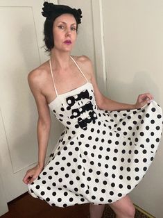 An iconic 80's look that's somehow timeless and tasteful!  Beautiful construction and quality fabrics, both noted qualities of Louis Féraud designs.  White cotton faille has body and feels luxurious.  Large black polka dot print, with three bows on bodice in reverse color scheme.  Tight bodice has stays on front and back for structure.  Narrow halter straps tie in back.  Bubble hem is given more volume with a panel of organza inserted between the faille and the nylon (?) lining.  Closes on c/b with a hidden zipper.   *HAT & JEWELRY NOT INCLUDED* In very condition.  Only flaw to note is minor fraying on ends of halter straps, and a little repair next to one of the knots.  It looks like they were possibly trimmed at some point? Marked a Size 4, but I'd estimate it's closer to a modern 2.   * 1970 Vintage Minnie Mouse Pendant With Green Polka Dot Dress, Polka Dot Mini Dress, 80s Look, Louis Feraud, Bubble Hem, Polka Dot Print, Black Polka Dot, Polka Dot Dress, Dot Print