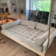 a living room with a swing bed and bookshelf