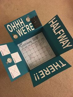 there is a calendar on the floor with words written on it and two pieces of paper attached to them