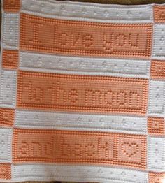 an orange and white crocheted blanket with the words love written on it in small letters