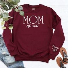 Custom Mama Sweatshirt With Kid Name On Sleeve, Personalized Mom Long Sleeve, Est Date Mom Outfit, Custom Momma Hoodie, Gift For Mother.   Welcome to our store!  -We specialize in funny, customizable apparel shirts in different colors and styles printed on ultra-soft, super comfortable, and breathable material.  -Solid colors 50/50 Preshrunk Cotton/Polyester -We use Gildan - Heavy Blend and one of the best quality products on the market. If there are personal designs you want, we can make custom Cotton Hooded Sweatshirt For Mother's Day, Winter Long Sleeve Sweatshirt With Name Print, Long Sleeve Hoodie With Letter Print For Mother's Day, Fall Sweatshirt With Name Print And Long Sleeves, Casual Name Print Sweatshirt For Winter, Winter Name Print Relaxed Fit Sweatshirt, Winter Crew Neck Sweatshirt With Name Print, Winter Sweatshirt With Name Print In Relaxed Fit, Casual Fall Hoodie With Name Print