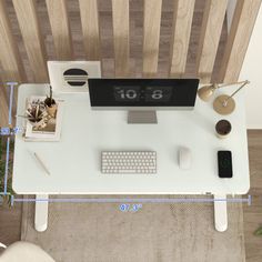 a computer desk with a clock on it and various office supplies around the table top