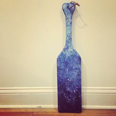 a blue vase sitting on top of a hard wood floor next to a white wall