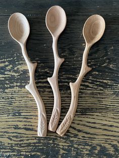 three wooden spoons sitting on top of a table