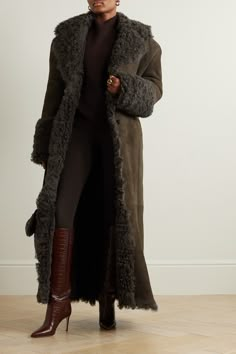 Magda Butrym tailors this brown coat with wide, padded shoulders nodding to exaggerated silhouettes from the ‘80s. It’s made from plush shearling offset with a curly collar and cuffs and falls to a dramatic floor-length hem. Cinch it with the belt or leave it open to relax the shape.