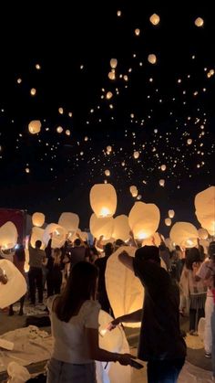 many people are releasing paper lanterns into the sky