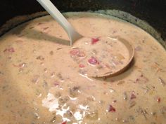 a wooden spoon in a pot filled with soup