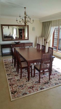 a dining room table and chairs with a rug on the floor