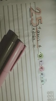 a pink pen sitting on top of a sheet of paper