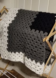 a crocheted blanket sitting on top of a wooden chair