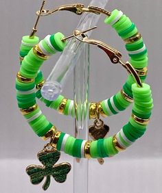 ☘️ St. Patrick's Day themed hoop earrings.  These gold toned hoops are 2 inches round and adorned with Green and White Heishi Beads with gold toned findings, added 2 beautiful charm clovers ☘️ for luck and a little bit of bling!  Thank you for supporting a veteran owned business! ❤️