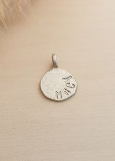 This personalized circle charm is the perfect addition to any charm bracelet or necklace. Made with a round shape, it can be customized with a name or initials, making it a unique and sentimental piece. Crafted with high-quality materials, it is sure to become a cherished accessory for years to come. Size: 18mm Available in sterling silver, gold plated over sterling silver, and rose gold plated over sterling silver. We can fit up to 8 characters (including spaces). Sterling Silver Charms Round Pendant For Gifts, Sterling Silver Round Pendant Charms For Gifts, Simple Personalized Pendant Charm Necklace, Sterling Silver Round Charms For Mother's Day, Personalized Small Charms For Gifts, Minimalist Round Charms For Gifts, Minimalist Round Gift Charms, Everyday Engraved Charm Necklace With Round Pendant, Personalized Small Charm Necklaces For Everyday