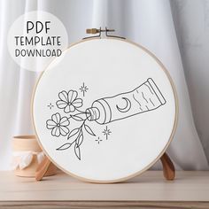 the embroidery pattern is being displayed in front of a white background with a wooden stand