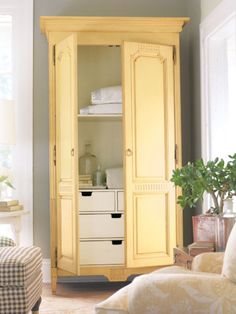 a yellow armoire in the corner of a living room